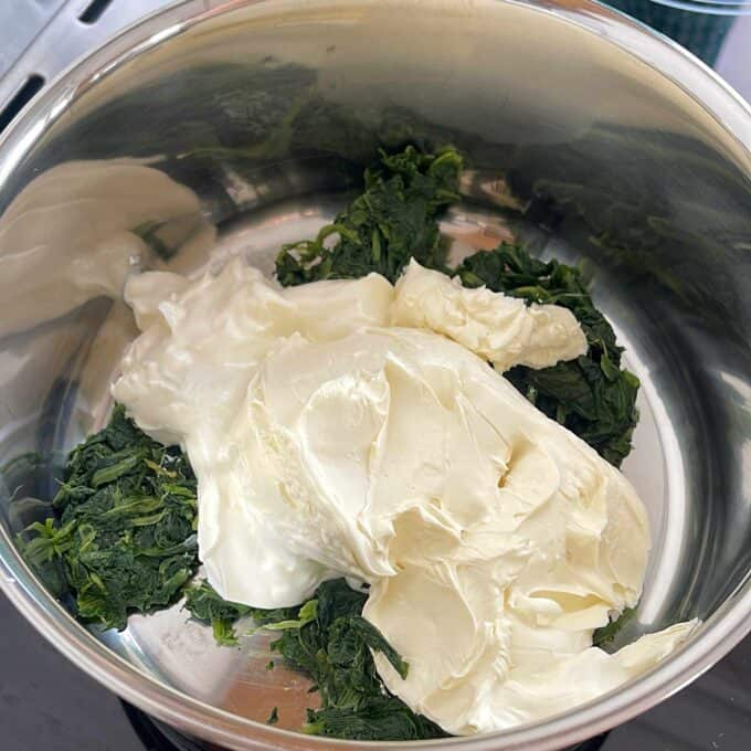 Creamy Spinach Cob Sliders A stainless steel bowl containing chopped spinach and a large dollop of cream cheese.
