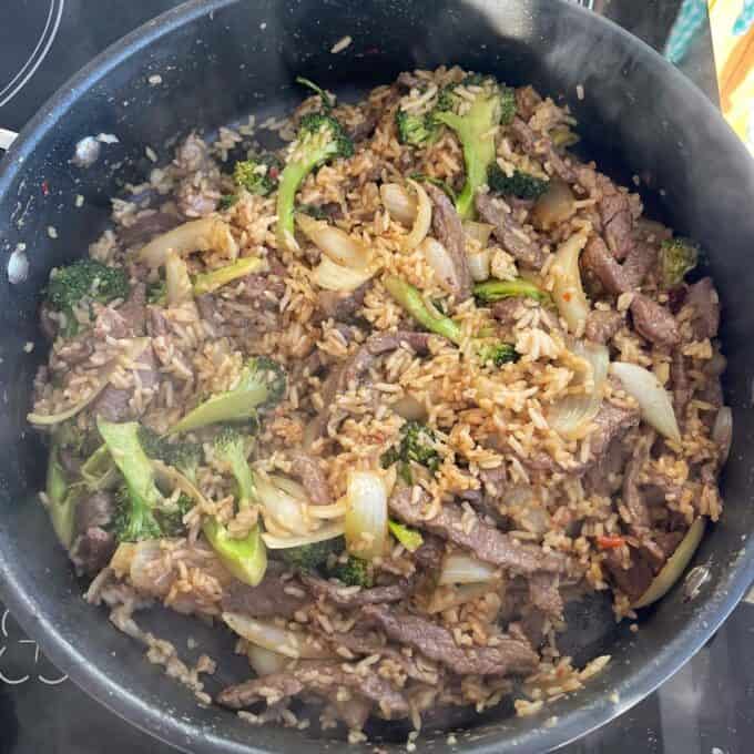 Beef and Broccoli Fried Rice A skillet containing beef stir-fry with rice, broccoli, and onions, cooked and mixed together.