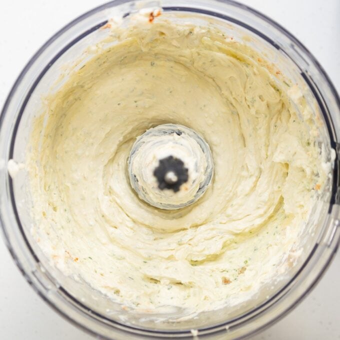 Christmas Cheeseball A food processor bowl filled with a creamy, blended mixture, viewed from above.