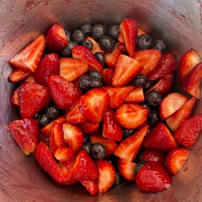 Fresh Berry Custard Tart A bowl filled with sliced strawberries and whole blueberries.