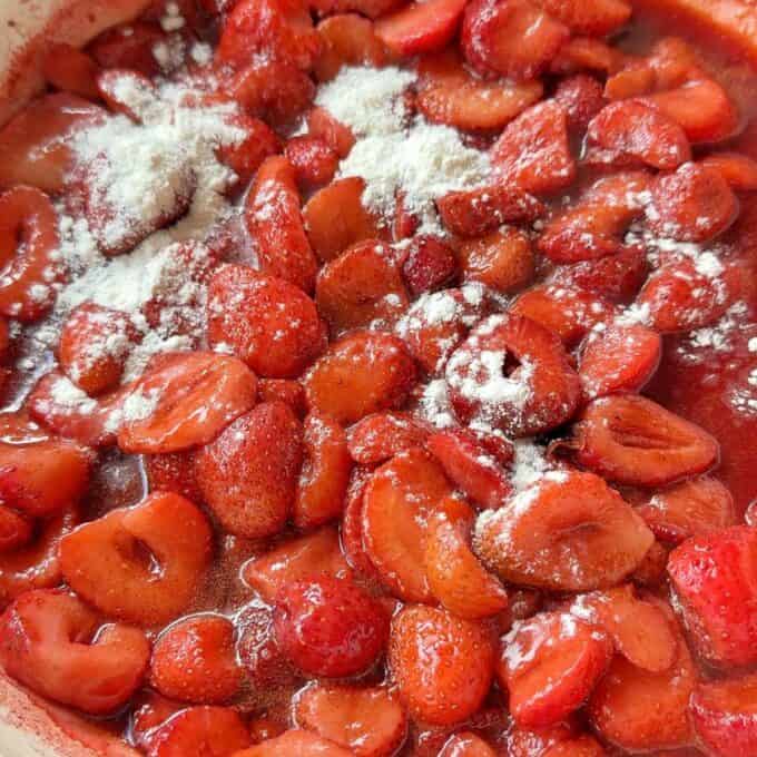 Strawberry Cobbler Sliced strawberries coated in sugar and sprinkled with flour in a mixing bowl, ready to be mixed or cooked.