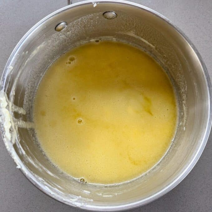 Feijoa and White Blondie A stainless steel pot containing melted butter with some foam on the edges sits on a gray countertop.