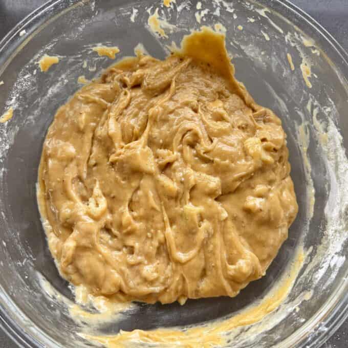 Feijoa Loaf A glass bowl filled with thick, light brown batter, partially mixed with visible streaks and clumps.
