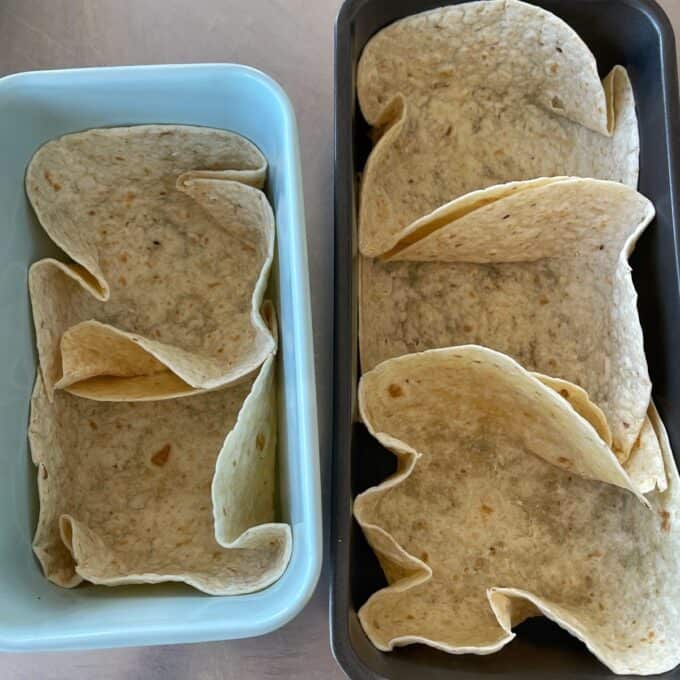 Loaded Chicken Tortilla Cups Two rectangular baking dishes each contain tortillas folded to fit and line the bottom and sides, ready for filling or baking.