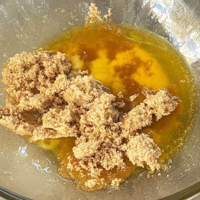 Feijoa and Pear Crumble Brown sugar and melted butter are combined in a glass mixing bowl.
