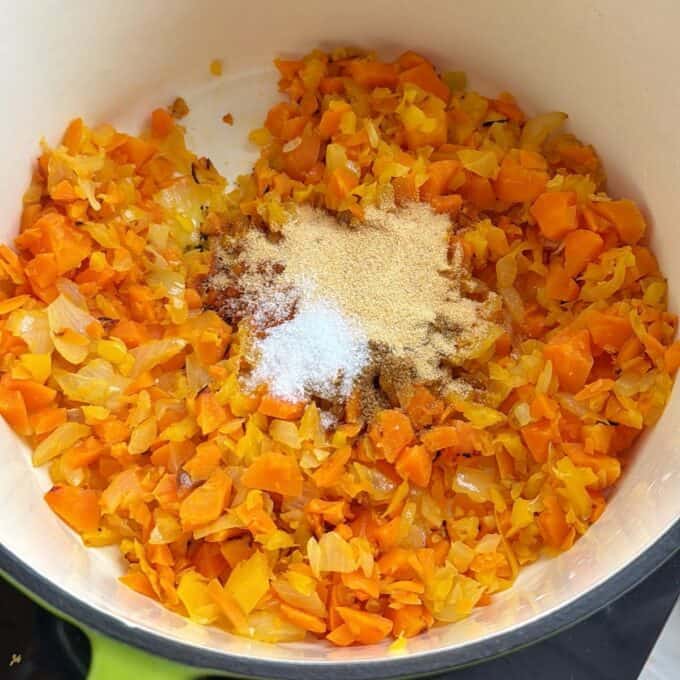 Baked Vegetarian Chilli Chopped carrots, onions, and possibly peppers in a pot with various powdered seasonings sprinkled on top.