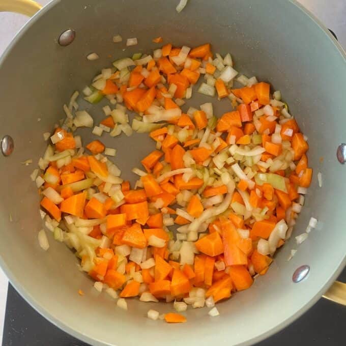 Chicken and Leek Pie Chopped carrots, onions, and celery are sautéing in a large pot.