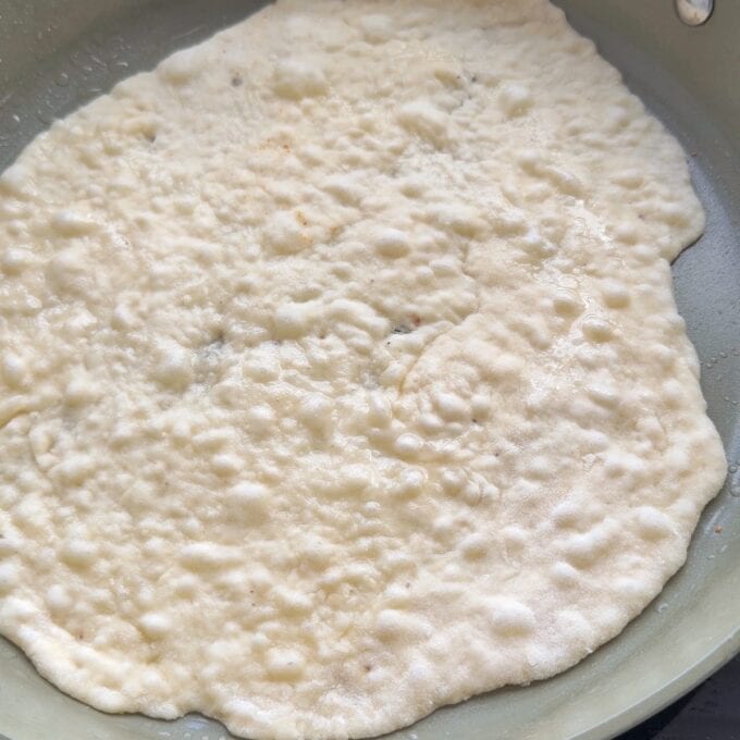 Lamb Koftas on Homemade Flatbreads A piece of flat, bubbly dough cooking in a frying pan.