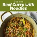 A one-pot beef curry with noodles, featuring beef, vegetables, and peanuts, garnished with lime wedges and cilantro.
