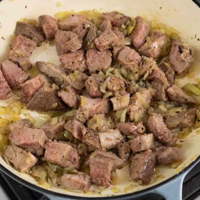 Shepherd's Pie Diced beef and chopped onions cooking in a pan.