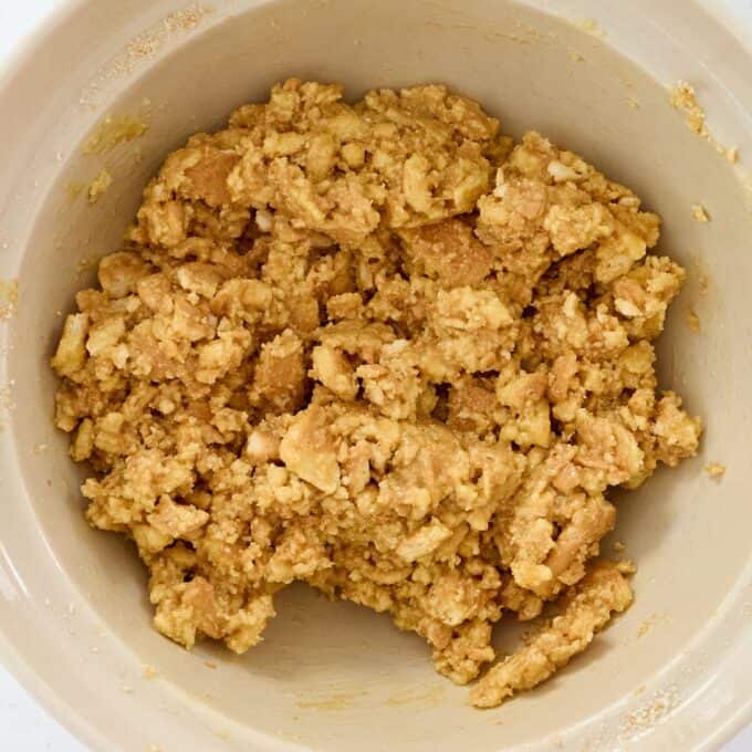 Sprinkle Biscuit Slice A beige mixing bowl filled with a crumbly, light brown dough mixture.