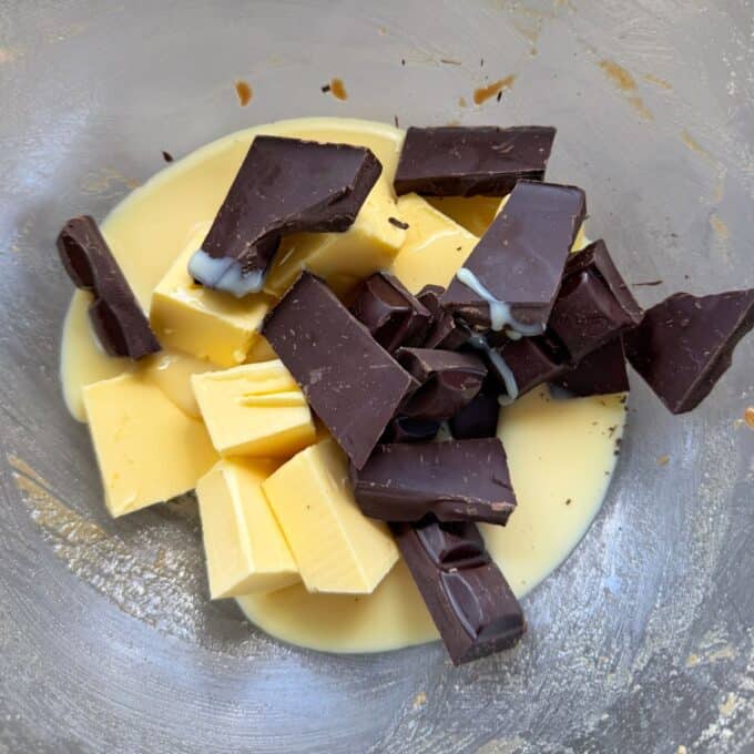 Love Heart Lolly Slice Chunks of dark chocolate, cubes of butter, and a pool of condensed milk in a metal mixing bowl.