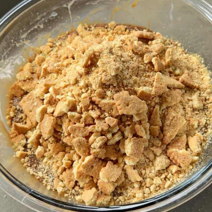 XL Pick and Mix Lolly Slice A glass bowl filled with crushed graham crackers or cookies, with both fine crumbs and larger pieces visible.