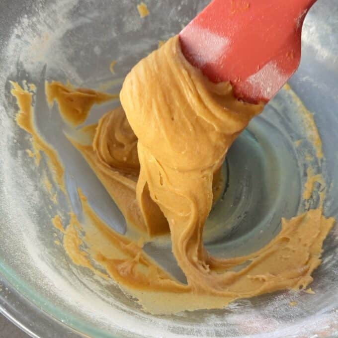 No-Bake Gingernut Slice A red spatula mixes thick cookie dough in a clear glass bowl.