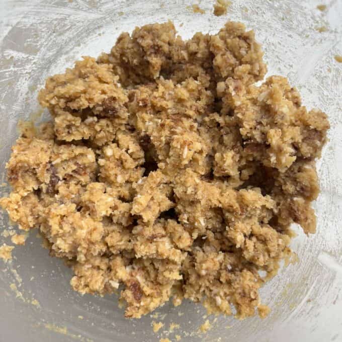 Gluten Free Bumper Bars A close-up view of cookie dough with visible chocolate chips in a clear mixing bowl.