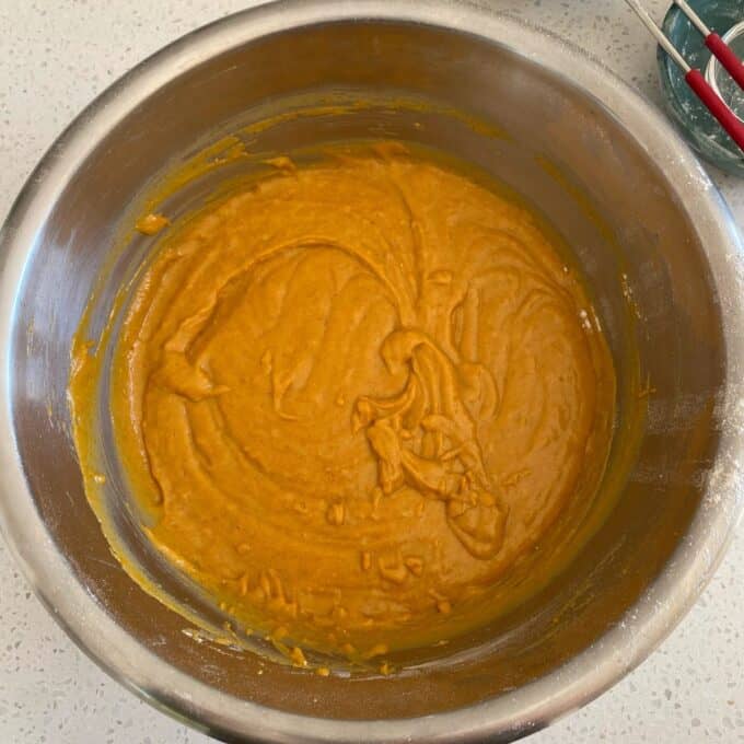 Pumpkin Spice Cake A metal mixing bowl contains thick orange-brown batter with some unmixed streaks visible along the sides.