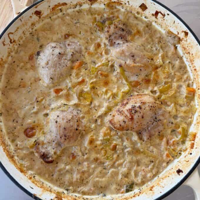 Creamy French Mustard Chicken Four pieces of seasoned chicken simmer in a creamy sauce with chopped vegetables in a large skillet.