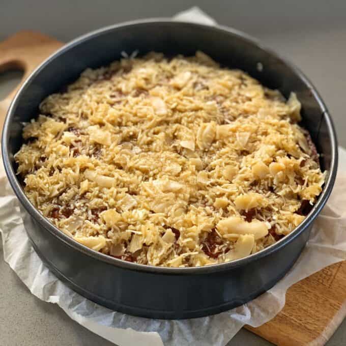 Lumberjack Cake A round cake in a springform pan topped with a layer of toasted shredded coconut.