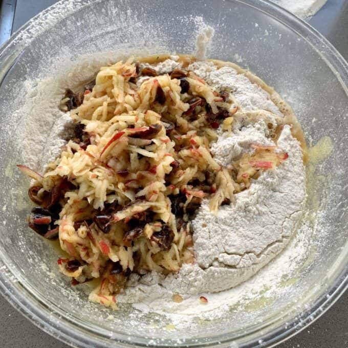 Lumberjack Cake A glass bowl containing a mixture of flour, shredded apples, and chopped dates.