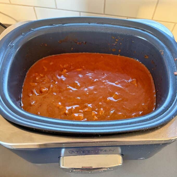 Slow Cooker Butter Chicken A dark blue GreenPan slow cooker filled with a thick, orange-red stew.