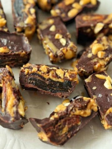 Pieces of dark chocolate candy filled with nuts and dried fruit.